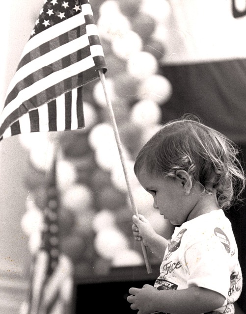 Black and white photo of child holding a flag